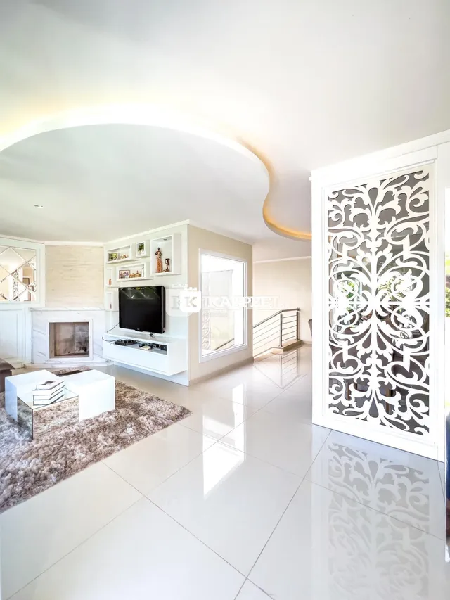 Sala de estar moderna com lareira e televisão em um ambiente claro.