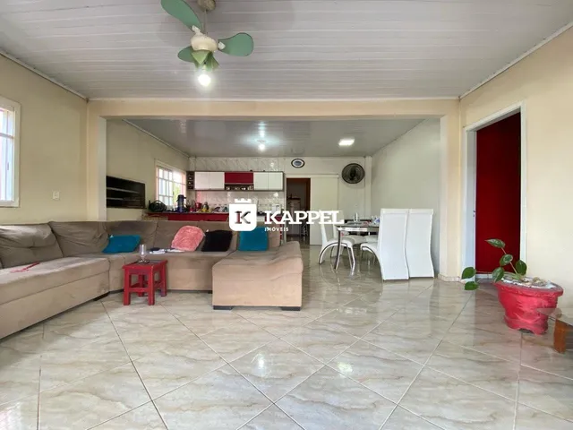 Sala de estar com sofá e mesa de jantar em um apartamento em Lajeado.