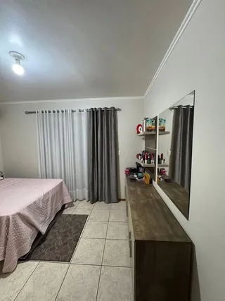 Foto de um quarto com cama e cortinas em um imóvel.