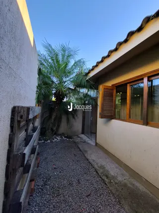 Fachada de uma residência em Lajeado, Brasil, com cerca de madeira e vegetação.