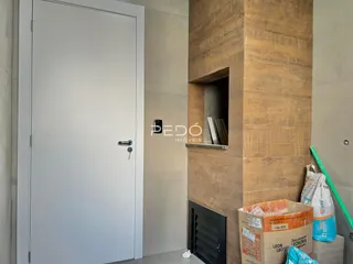Foto de um corredor interno com uma porta branca e uma coluna de textura na parede.