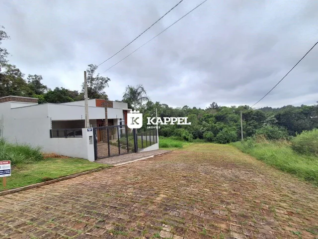 Fachada de uma casa branca com área externa e jardim.