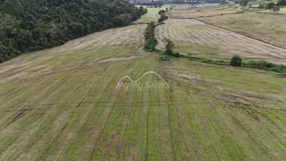 Vista aérea de uma área rural com campos abertos e vegetação densa.
