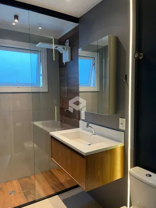 Foto de um banheiro moderno com box de vidro e bancada de madeira.