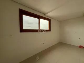 Vista interna de um ambiente com paredes brancas e piso de cerâmica.