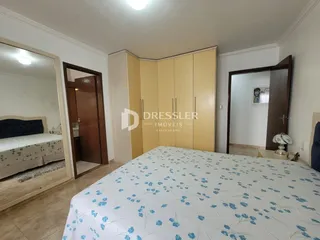 Quarto com cama e armários em um ambiente claro.
