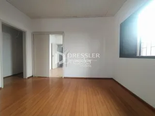 Interior com piso de madeira e portas em uma sala.