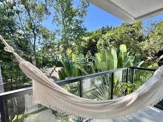 Vista da varanda com vegetação exuberante e paisagem verde.