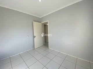Interior de um ambiente com piso de cerâmica e porta branca.