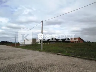 Vista externa de uma propriedade com área pavimentada no entorno.
