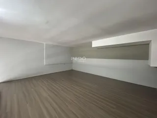 Ambiente interno de uma sala com piso de madeira clara.