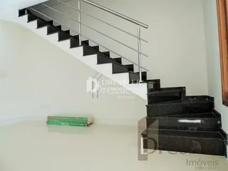 Escadaria preta com corrimão metálico em um ambiente interno.