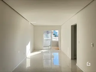 Corredor interno de uma residência com paredes brancas e piso claro.