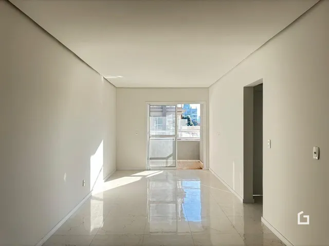Corredor interno de uma residência com paredes brancas e piso claro.