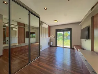 Ambiente interno de uma sala de estar com piso de madeira e portas de vidro.