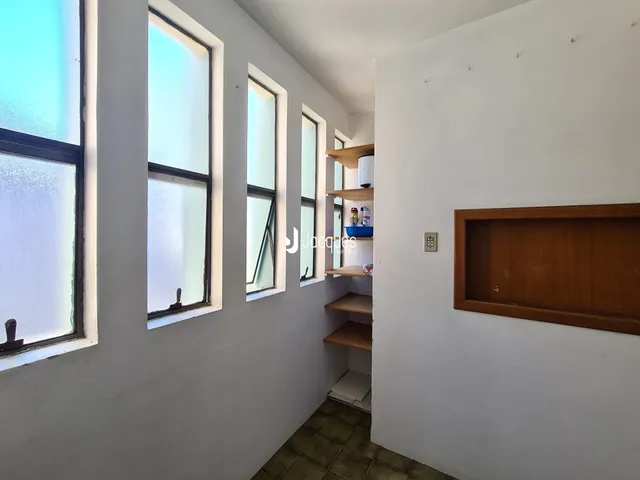 Vista de um corredor com janelas altas em uma residência.