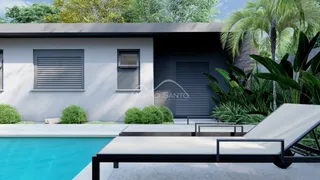 Fachada de uma casa moderna com piscina e vegetação tropical.