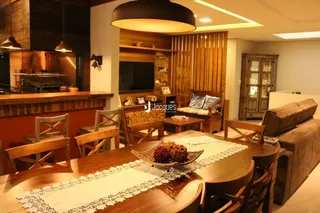 Sala de estar com mesa de madeira e lareira em ambiente interno.
