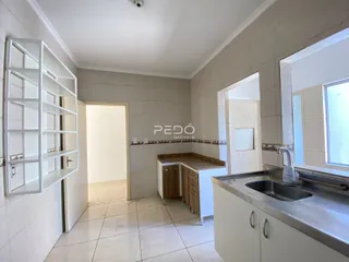 Interior de um corredor com armário e bancada de cozinha em imóvel no Brasil.