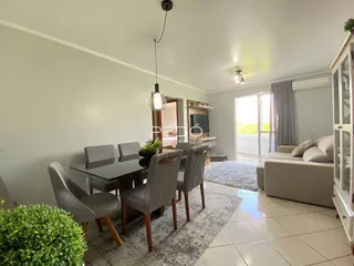 Sala de estar com mesa de jantar e sofá em um imóvel no Brasil.