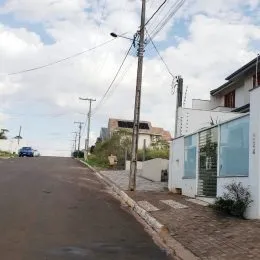 Vista de uma rua em Lajeado, Brasil, com postes e fiação elétrica.