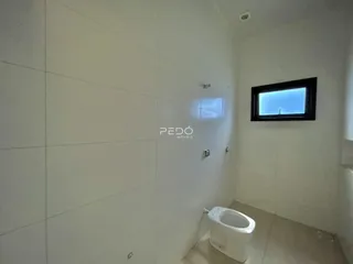 Hall de banheiro com piso claro e paredes brancas.