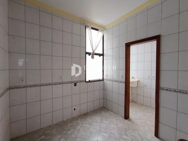 Interior de uma sala com piso e paredes revestidos de cerâmica.