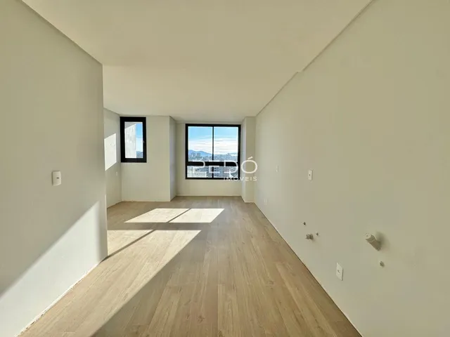 Ambiente interno com piso de madeira clara e paredes brancas.