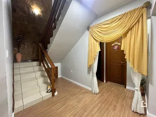 Hall de entrada com escadaria e parede de pedra na residência.