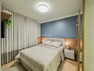 Foto de um quarto com cama e cortinas brancas em um imóvel.
