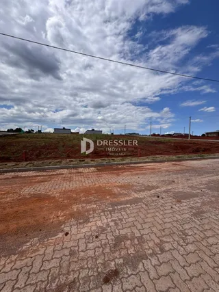 Vista externa de uma propriedade com edificações ao fundo.