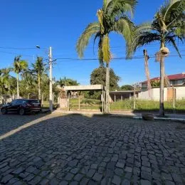 Vista externa de uma área pavimentada com palmeiras em Lajeado.