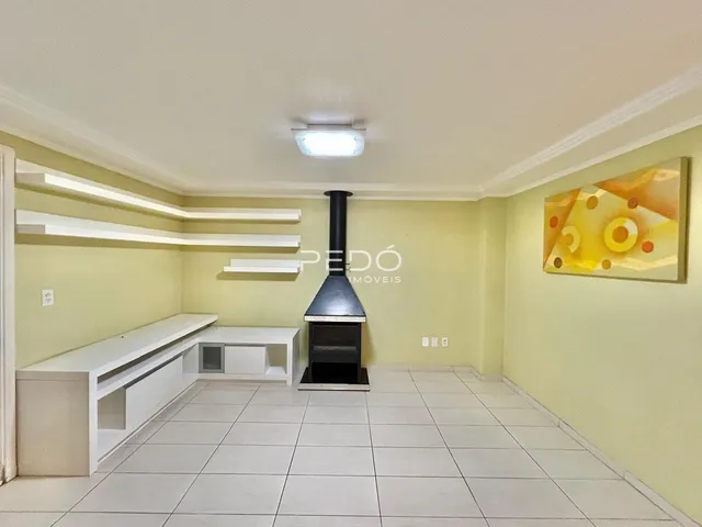 Sala de estar com piso de cerâmica e estantes brancas.