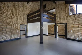 Interior de um espaço com paredes de tijolo aparente e piso de cerâmica.