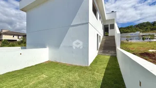 Fachada branca de uma residência em Lajeado, Brasil, com jardim gramado na frente.
