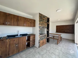 Cozinha com armários de madeira e parede de pedra.