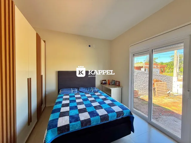Quarto com cama grande e porta de vidro que dá acesso ao exterior.