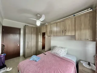 Quarto com armários de madeira e cama em um imóvel no Brasil.
