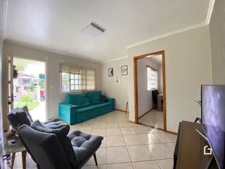 Sala de estar com sofá azul e piso de cerâmica clara.