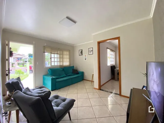 Sala de estar com sofá azul e piso de cerâmica clara.