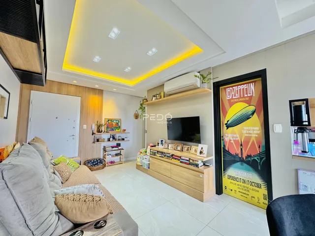 Sala de estar moderna com sofá e painel de madeira em um imóvel no Brasil.