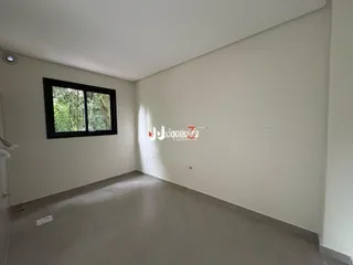 Foto de uma sala interna com paredes brancas e piso claro.