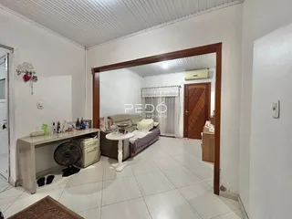 Sala de estar com piso de cerâmica clara e porta de madeira.