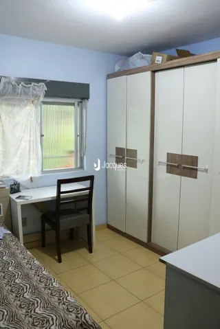 Quarto com armário embutido e piso de cerâmica.