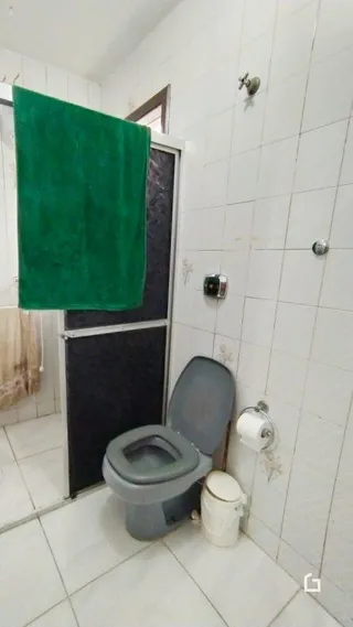 Foto de um banheiro com revestimento de azulejos brancos.