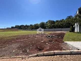 Vista externa de um terreno com vegetação e cerca no fundo.