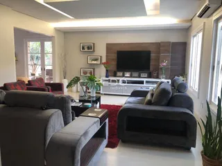 Sala de estar moderna com sofá e televisão em um apartamento no Brasil.