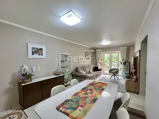 Sala de estar com mesa de jantar e sofá em um imóvel no Brasil.