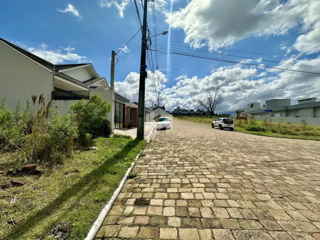 Vista da fachada de uma residência em Lajeado, Brasil, com uma rua pavimentada e vegetação lateral.