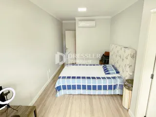 Quarto interno com cama e paredes claras.
